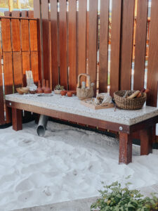 wooden table contains basket and other things placed at white sand