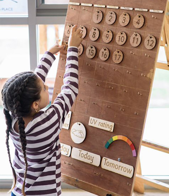 A girl child is learning to place numbers on number board