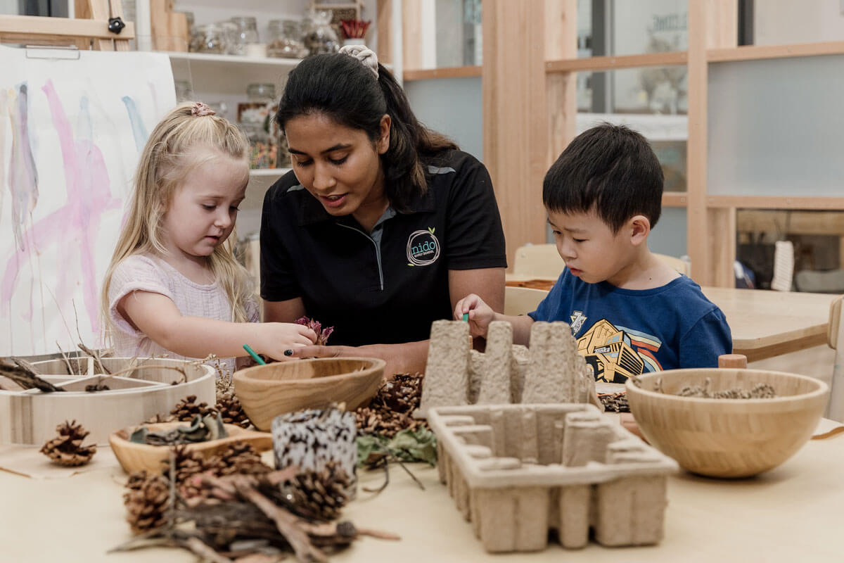 Nido educators help children play with natural materials for hands-on sensory experiences
